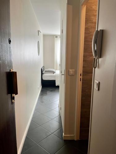 un couloir avec une chambre avec un lit et une porte dans l'établissement Studio à Alfortville Gare RER D Maisons-Alfort Alfortville, à Alfortville