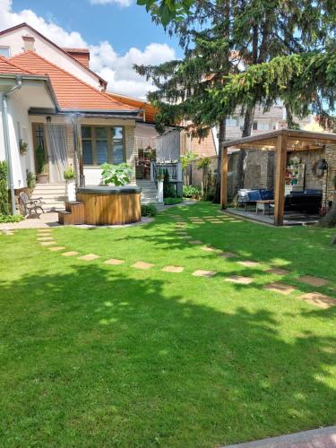 a house with a yard with a lawn sidx sidx sidx at Belvárosi Kertesház in Keszthely