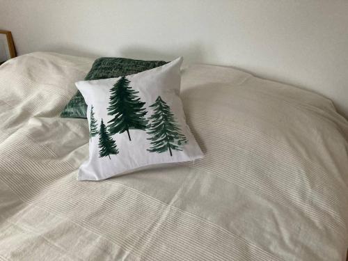 a bed with a pillow with pine trees on it at Neues Penthouse-Loft mit KONUSKarte für gratis ÖPNV in Ehrenkirchen