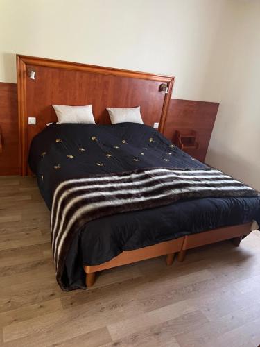 1 dormitorio con 1 cama con cabecero de madera en Maison Hyacinthe of Tournesol geniet in luxe, en Castelnaud La Chapelle