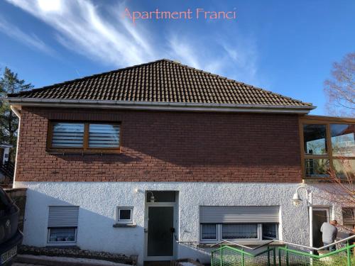 a brick house with a brown roof at Apartment Franci in Wiebelskirchen