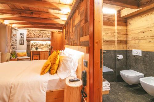 a bedroom with a bed and a tub and a sink at Agriturismo Ferdy in Lenna