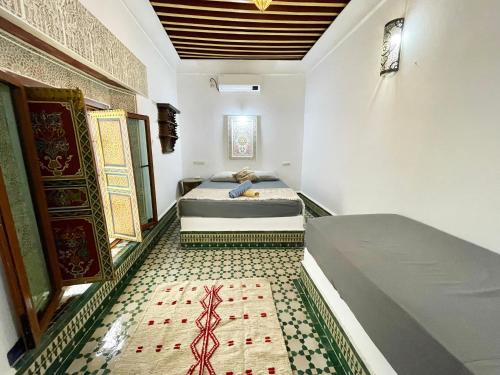 two beds in a room with a tile floor at Dar Sunrise Fes in Fès