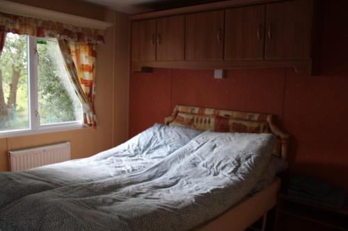 un letto non rifatto in una camera da letto con finestra di Ośrodek Wypoczynkowy "Marina Rozbejko" a Myślibórz