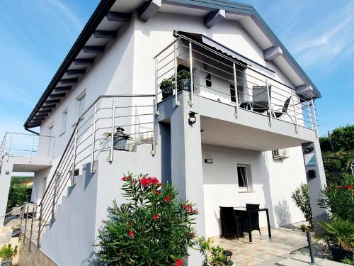 a white house with a balcony and flowers at Apartments Villa Ines Skofije -near Koper in Zgornje Škofije