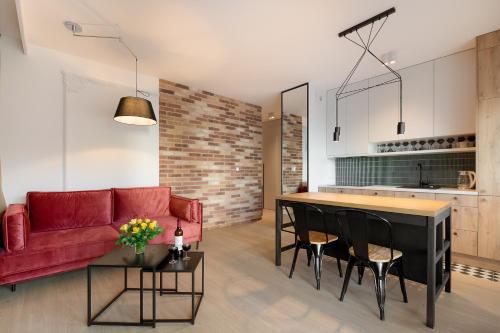 ein Wohnzimmer mit einem roten Sofa und einem Tisch in der Unterkunft Harmonia Apartament with Parking in Toruń