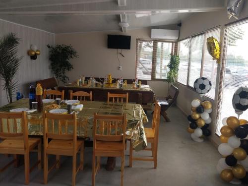 ein Esszimmer mit einem Tisch, Stühlen und Ballons in der Unterkunft Къща за гости Релиса in Razgrad