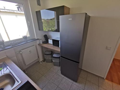 a kitchen with a refrigerator and a sink in it at Work & Stay 3 Room Apartment in Plettenberg