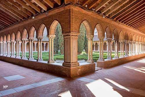 un bâtiment avec des colonnes et des arches dans une cour dans l'établissement LE COEUR DE FALGUIERE - Hypercentre - Gare, à Toulouse