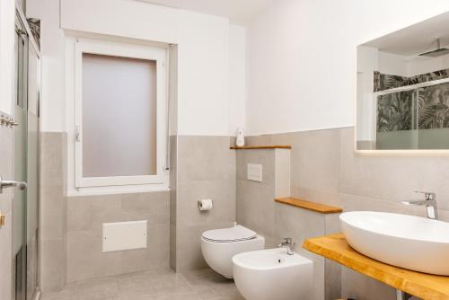a bathroom with a white sink and a toilet at La Casa di Ambra in Porto Torres