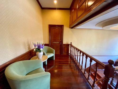 a hallway with two chairs and a table with flowers at Orchid Pool Villa Phuket - SHA Extra Plus in Phuket Town