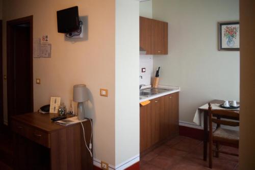 a small kitchen with a sink and a table at Hotel Ciocca in Castelnuovo Don Bosco