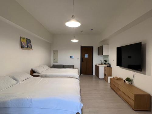 Habitación de hotel con 2 camas y TV de pantalla plana. en Sunrise Hot Spring House en Toucheng