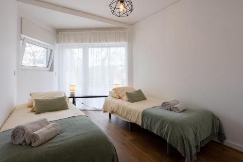 two beds in a room with a window at MHouse lease Cascais Av 25 Abril in Cascais