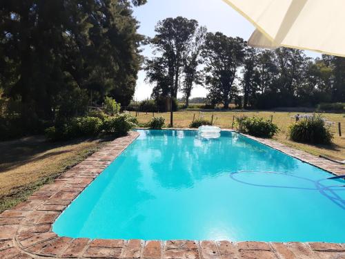 a blue swimming pool with a brick pathway around it at Casa de campo Spaequino La Colorada in T. Yofré