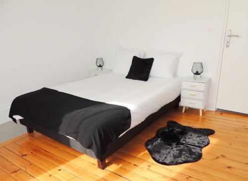 - une chambre avec un lit blanc et une couette noire dans l'établissement Appartement Cosy, à Poissy
