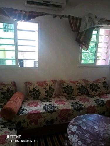 a living room with a couch and two windows at السخينات in Es Skhinat