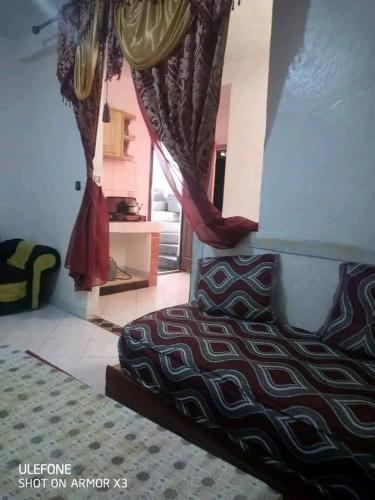 1 dormitorio con 1 cama y una ventana con cortinas en السخينات, en Es Skhinat