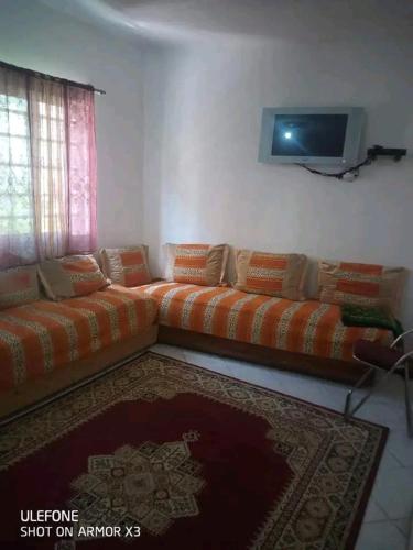 a living room with a couch and a tv at السخينات in Es Skhinat