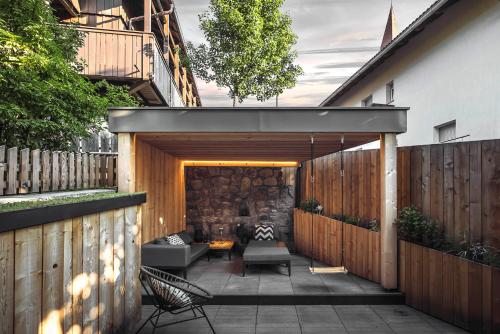 a backyard with a wooden fence and a patio at Rousa little guesthouse Kombi in Rasun di Sopra