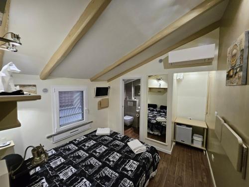 Una pequeña habitación con una cama y un espejo. en The Fox Cove, en Roma