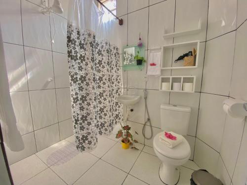 a bathroom with a toilet and a shower curtain at Casa Praia a Beira Mar Guriú Ceará in Guriú