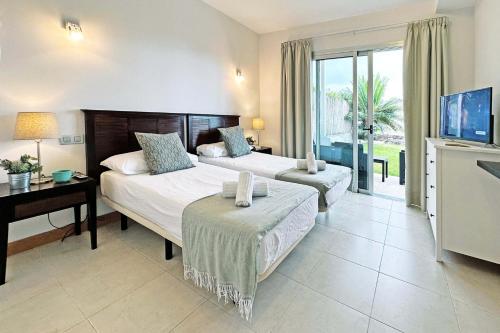 マスパロマスにあるSalobre Vista Golf 29のベッド2台とテレビが備わるホテルルームです。