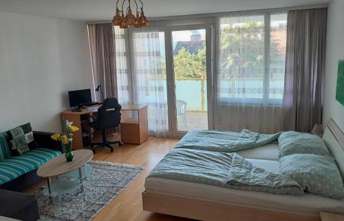 Schlafzimmer mit einem Bett und einem Schreibtisch mit einem Computer in der Unterkunft Serviced Apartment with Sunny Balcony in Wien