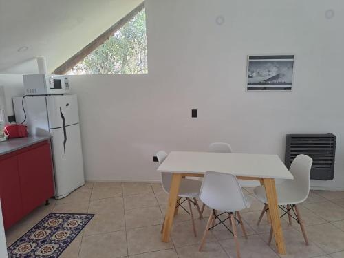 a kitchen with a table and chairs and a refrigerator at El Refugio Nuevo y cómodo depto Excelente ubicacion in San Carlos de Bariloche