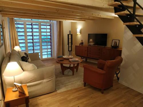 - un salon avec un canapé et une télévision dans l'établissement Le Studio du Château (2 à 4 personnes), à Clisson