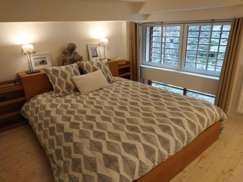 a bedroom with a large bed with a large window at Le Studio du Château (2 à 4 personnes) in Clisson