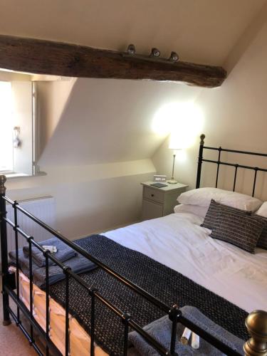 a bedroom with a large bed with a black frame at Little Gem on Bridgnorth's Cartway. River Views in Bridgnorth