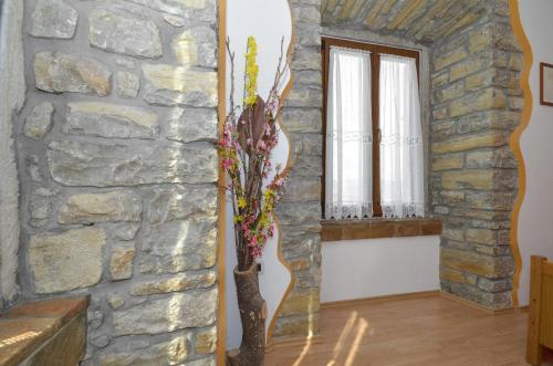 a room with a stone wall and a vase with flowers at Bella Vista Apartments in Motovun