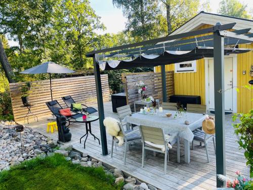 une terrasse avec une table et un parasol dans l'établissement Villa Lillgården with Sauna and Jacuzzi, à Norrköping