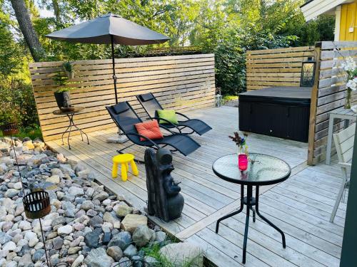 a patio with a table and chairs and an umbrella at Villa Lillgården with Sauna and Jacuzzi in Norrköping