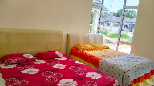 twee bedden naast elkaar in een kamer bij Homestay Dena Moon Inn in Tumpat