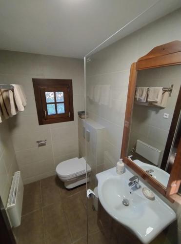 a bathroom with a sink and a toilet and a mirror at Őrségi Porta in Magyarszombatfa