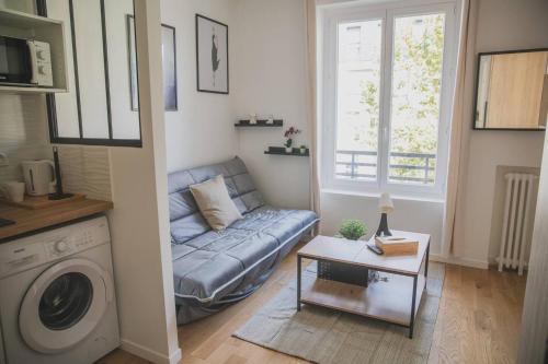 un salon avec un canapé et une machine à laver dans l'établissement Très beau studio 1, à Asnières-sur-Seine