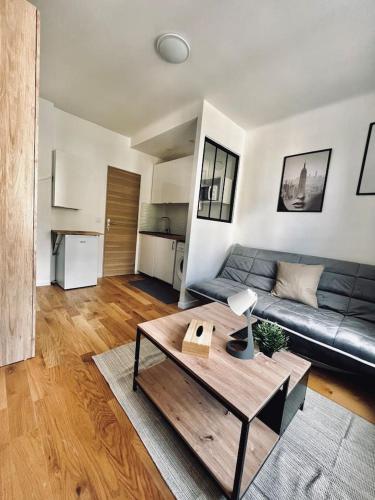 Una sala de estar con un sofá y una mesa de café. en Très beau studio 1, en Asnières-sur-Seine