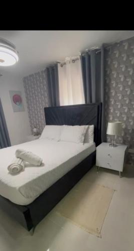 ein Schlafzimmer mit einem großen Bett und einem Nachttisch in der Unterkunft Garden city apartamento de 3 habitaciones in Santo Domingo