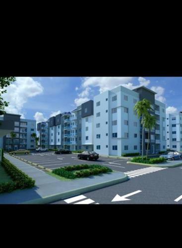 einen Parkplatz mit Gebäuden und einem Auto in der Unterkunft Garden city apartamento de 3 habitaciones in Santo Domingo