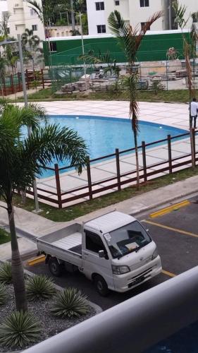 ein weißer LKW, der neben einem Schwimmbad parkt in der Unterkunft Garden city apartamento de 3 habitaciones in Santo Domingo