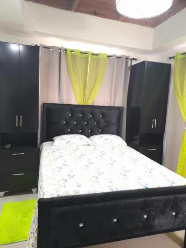 a bedroom with a bed with a black head board at Garden city apartamento de 3 habitaciones in Santo Domingo