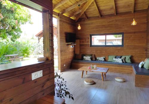 Habitación de madera con mesa y banco en Odyssea Caraïbes Cottages & Spa en Saint-Louis