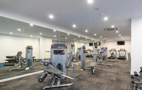 a gym with several tread machines and mirrors at Comfortable Living - NO PARTIES- 3 Bedroom sleeps 6, parking, pool, other amenities - Near Showgrounds in Sydney