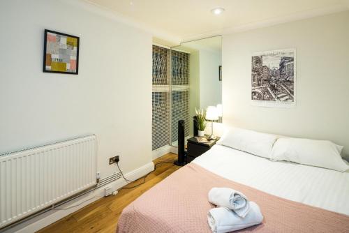 - une chambre avec un lit et une serviette dans l'établissement Cozy 1 bedroom / Gloucester Road / Kensington, à Londres