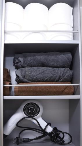 une étagère avec un sèche-cheveux et un ventilateur dans un placard dans l'établissement Malang Home, à Séoul
