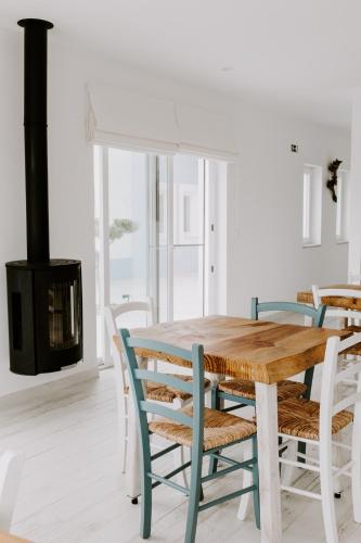 a dining room with a table and chairs and a fireplace at À Espera - Turismo Rural,Melides in Melides