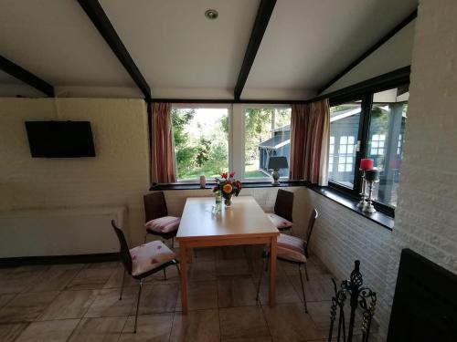 - une salle à manger avec une table, des chaises et des fenêtres dans l'établissement Eifel Residence 2, à Gerolstein