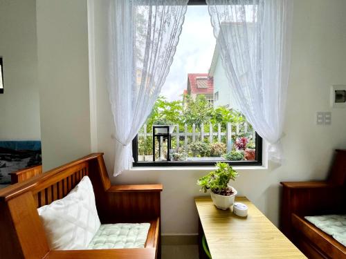 um quarto com uma janela com um banco e uma mesa em Mini Home em Ấp Ða Lợi